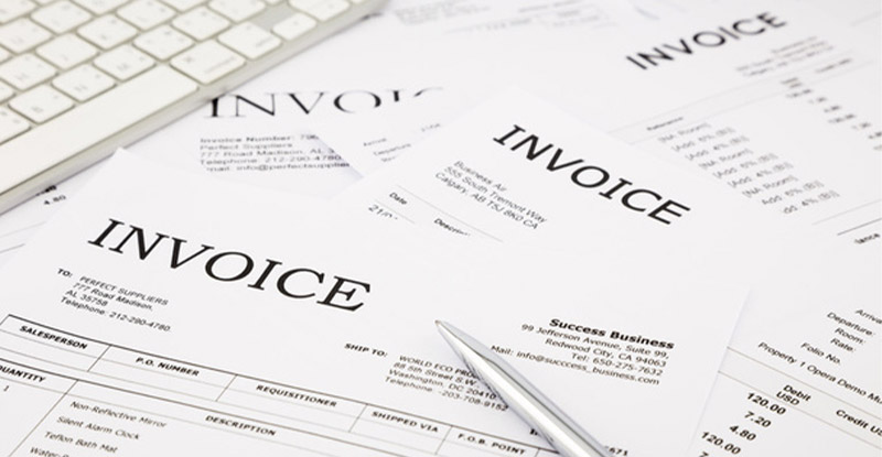 Various invoices on the table illustrating the need in invoicing software